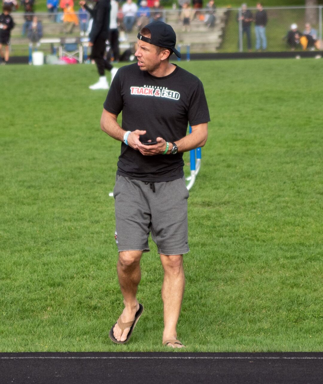 Head coach Kris Sauer monitors times at Blake. Photo by Ezra Victor.