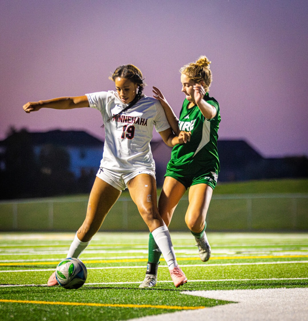 Sinae Hill keeps the soccer ball away from a defender.